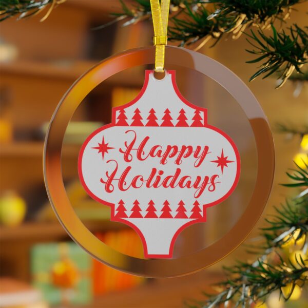 Happy Holidays glass ornament with festive red lettering hanging on a Christmas tree